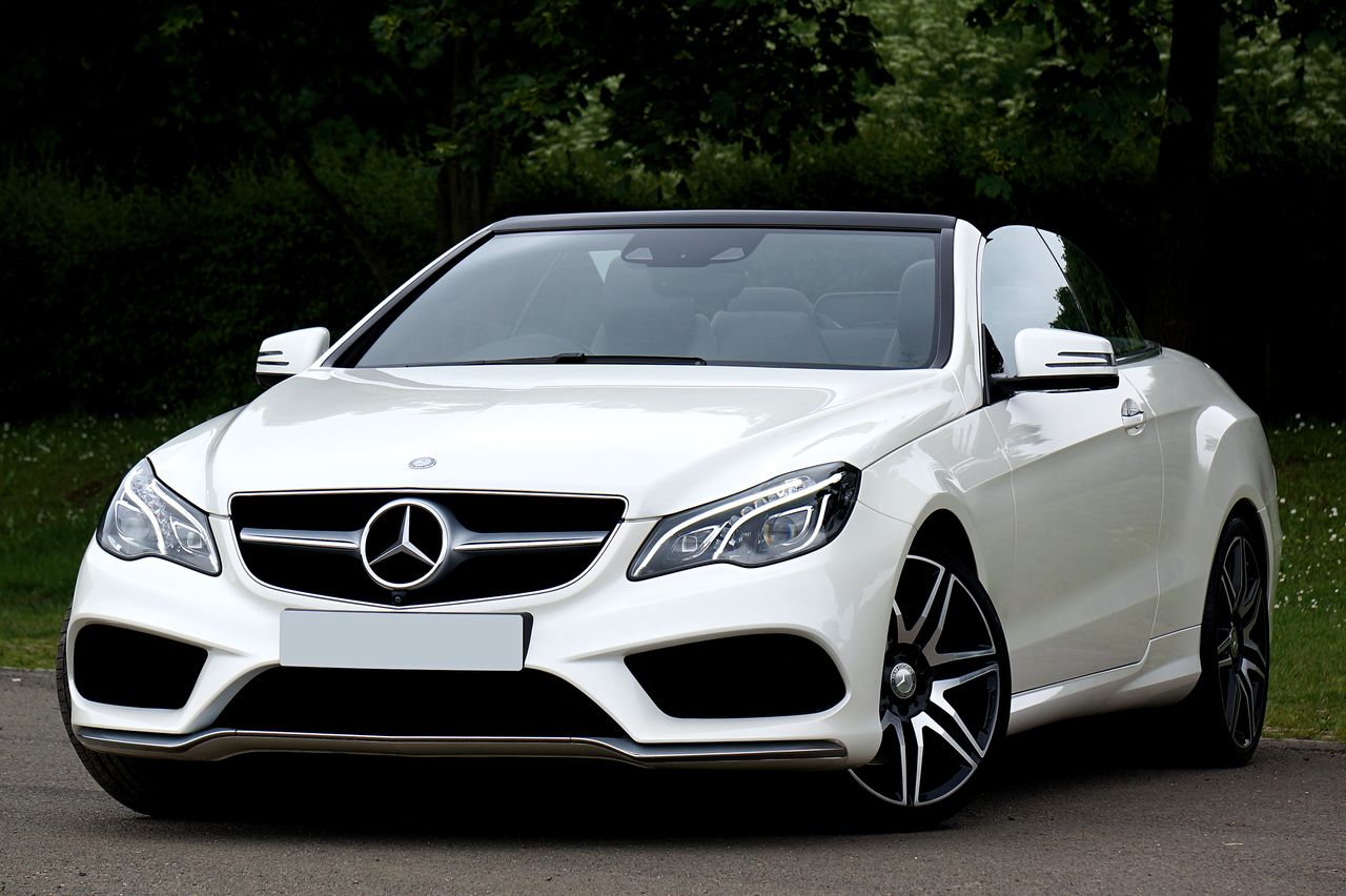White Mercedes-Benz convertible car parked outdoors showcasing luxury and style.